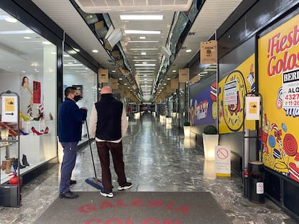 Un "arbolito" conversa con el encargado de limpieza de una galería sin ningún cliente.