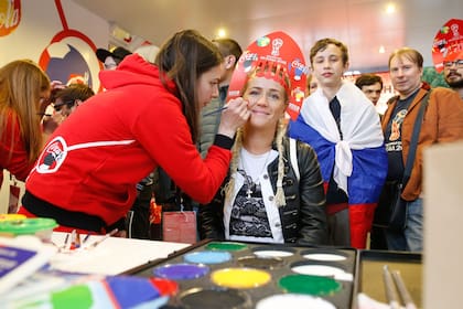 Una maquilladora pinta la bandera rusa en la cara de una visitante en la tienda oficial del FIFA Fan Fest en Moscú