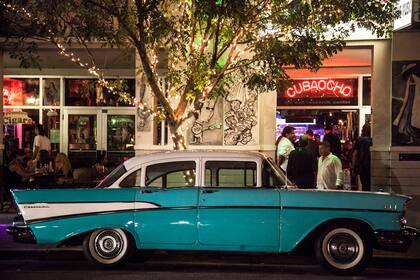 Un auto clásico en la puerta de CubaOcho, el meeting point nocturno de la comunidad.