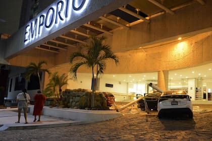 Un auto resulta dañado por la caída de rayos mientras la gente permanece afuera de un hotel después del terremoto en Acapulco, estado de Guerrero, México.
