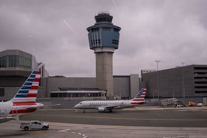 Un avión de American Eagle pasa junto a la torre de control de tráfico aéreo en el Aeropuerto LaGuardia (LGA) en Nueva York, el domingo 9 de noviembre de 2025. (Foto AP/Adam Gray)