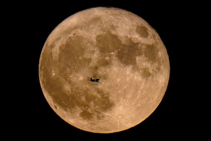 Un avión pasa frente a una superluna, el 13 de julio de 2022, en Milwaukee. (AP Foto Archivo/Morry Gash, Archivo)