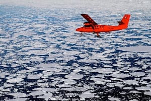 Un avión sobrevuela bloques de hielo derretido en las costas de la Antártida