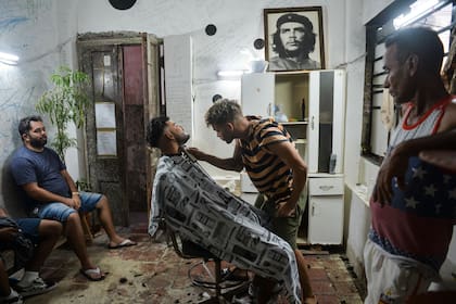 Un barbero corta la barba de un cliente en una barbería de La Habana, el 7 de agosto de 2019