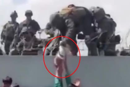 Un bebé es entregado sobre el muro del aeropuerto de Kabul a las tropas estadounidenses