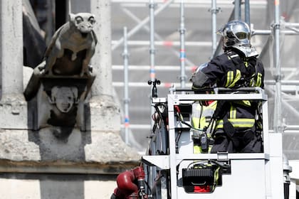 Un bombero inspecciona una de las gárgolas en el perímetro de Notre Dame