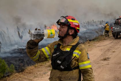 Un bombero toma agua en durante un descanso en Ituzaingó, Corrientes