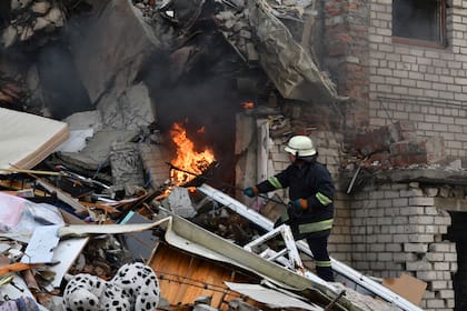 Un bombero trabaja en un edificio residencial dañado tras un bombardeo ruso en la región de Donetsk