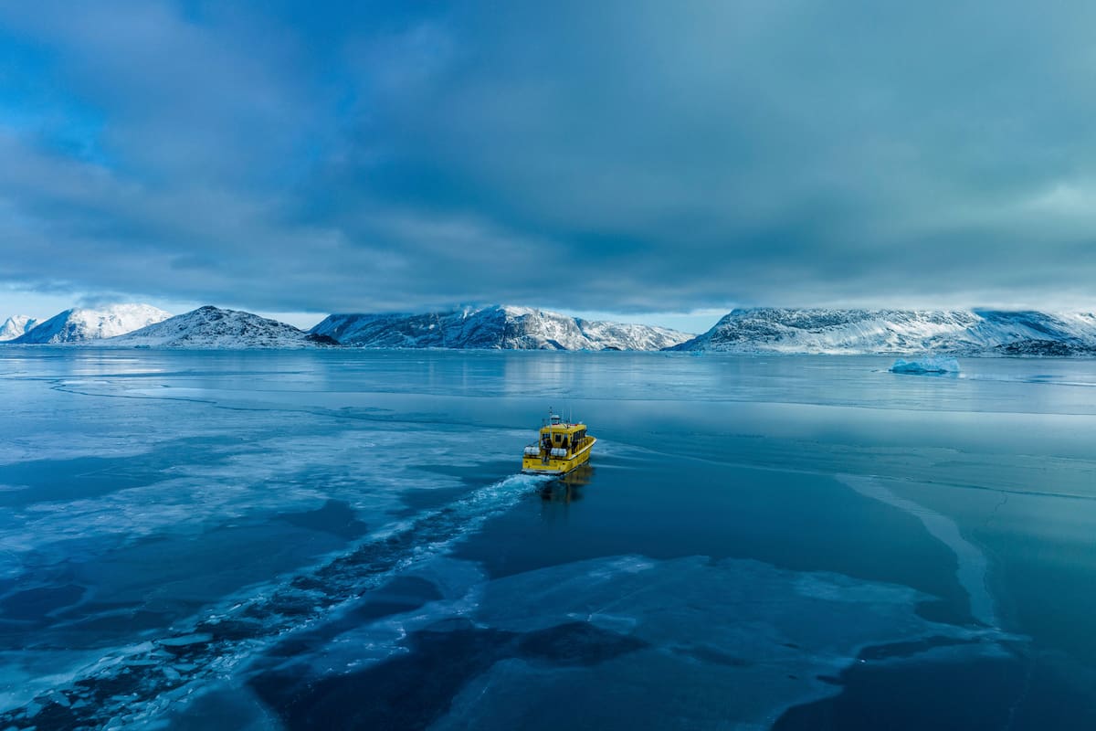 Un bote navega a través de una entrada de mar congelado en las afueras de Nuuk, Groenlandia, el 6 de marzo de 2025