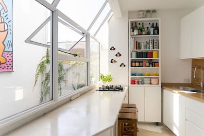 Un bow window sirvió para sumar una mesada y bajo mesada completa a la cocina y muchísima luz.