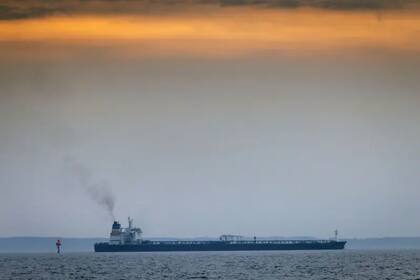 Un buque de la flota fantasma transitando frente a la pequeña isla danesa de Agerso, donde pescadores y bañistas ven a diario cómo viejos petroleros transportan petróleo ruso a través del estrecho danés