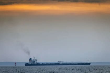 Un buque de la flota fantasma transitando frente a la pequeña isla danesa de Agerso, donde pescadores y bañistas ven a diario cómo viejos petroleros transportan petróleo ruso a través del estrecho danés