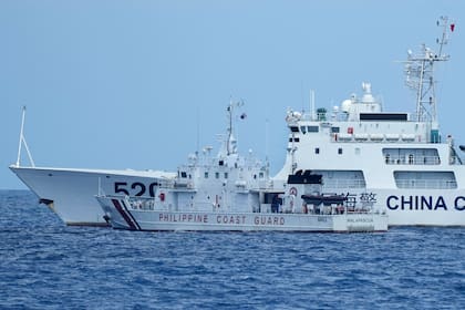 Un buque de la Guardia Costera de China bloquea el paso al buque de la Guardia Costera Filipina BRP Malapascua mientras maniobra para entrar al Second Thomas Shoal, conocido localmente como el banco de arena Ayungin, en el mar de la China Meridional, el domingo 23 de abril de 2023. (AP Foto/Aaron Favila)