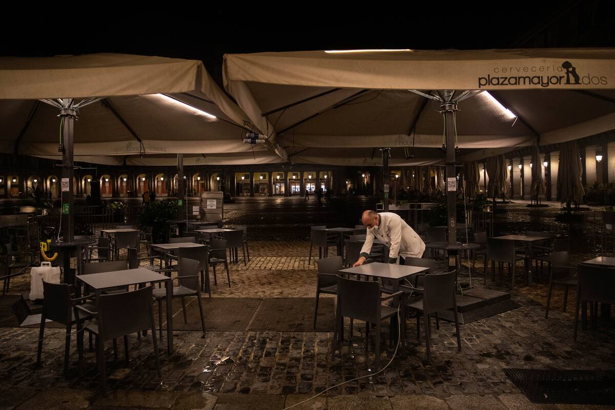 Un camarero cierra la terraza de un bar en la plaza Mayor en el centro de Madrid, España, el viernes 23 de octubre de 2020.