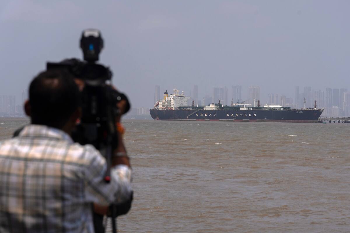 Un camarógrafo graba al petrolero con bandera india LPG Jag Vasant, que lleva gas licuado de petróleo tras pasar por el estrecho de Ormuz