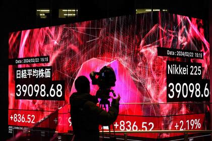 Un camarógrafo graba un tablero electrónico que muestra las cifras de cierre del índice Nikkei de la Bolsa de Valores de Tokio en Tokio