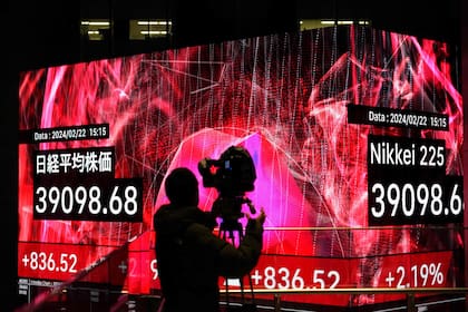 Un camarógrafo graba un tablero electrónico que muestra las cifras de cierre del índice Nikkei de la Bolsa de Valores de Tokio en Tokio
