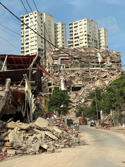 Un camino rodeado de pura destrucción, con edificios hechos polvo y otros a duras penas en pie