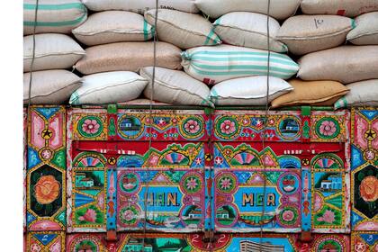 Un camión decorado que lleva sacos de trigo en Charsadda