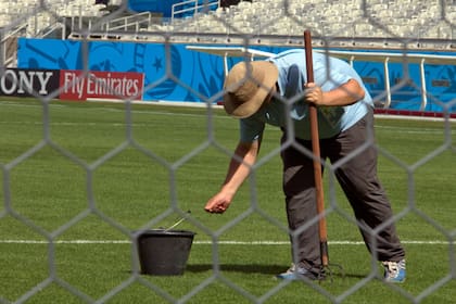 Un canchero arregla el césped del estadio Mineirao