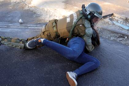 Un carabinero detiene a una manifestante en las calles de Santiago