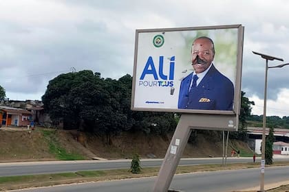 Un cartel con la imagen del presidente de Gabón, Ali Bongo Ondimba, donde el rostro fue vandalizado, en una calle vacía en Libreville