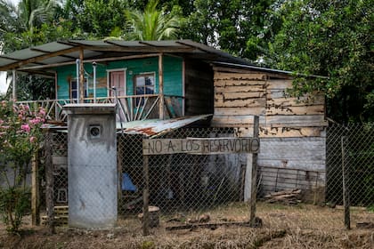 Un cartel escrito a mano frente a la casa de Hernandez en contra del reservorio