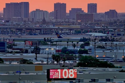 Un cartel muestra la temperatura no oficial de 108 grados Fahrenheit (42,2 grados Celsius) frente al Aeropuerto Internacional Sky Harbor, el 12 de julio de 2023, en Phoenix