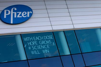 Un centro de manufactura de Pfizer en Puurs, Bélgica; el cartel dice: "Con cada dosis crece la esperanza, ganará la ciencia"