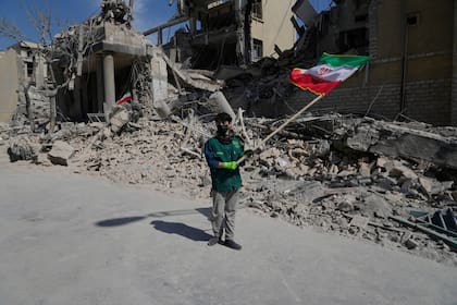 Un chico agita una bandera iraní frente a una instalación policial alcanzada durante la campaña militar de Estados Unidos e Israel en Teherán, Irán, el 4 de marzo de 2026