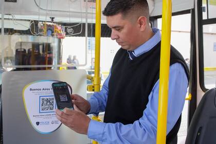 Un chofer de colectivos escanea el códigos QR pegado en la unidad que conduce; el sistema le permitirá a los pasajeros realizar denuncias en forma inmediata