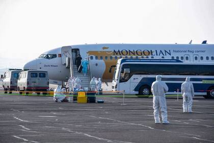 Un ciudadano mongol desciende de un avión luego de evacuar desde Wuhan en Ulan Bator, Mongolia el 1 de febrero de 2020