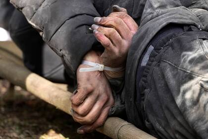 Un civil muerto con las manos atadas a la espalda yace en el suelo en Bucha, cerca de Kiev, Ucrania, el lunes 4 de abril de 2022