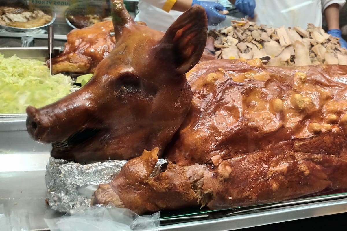 Un clásico: cerdo horneado entero hecho en cocción a leña en un horno por largas horas, que logra una piel crujiente y brillante y una textura blanda