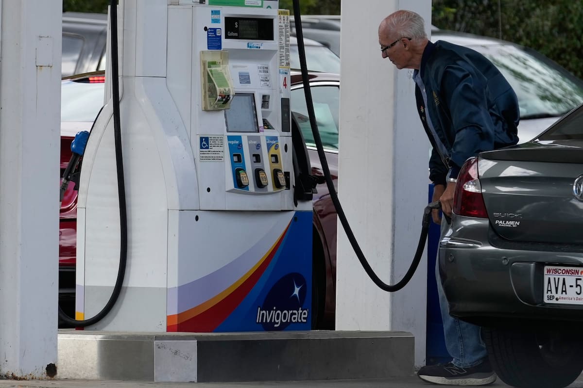 Un cliente consulta el precio de la gasolina al llenar el depósito de su auto en una gasolinera en R