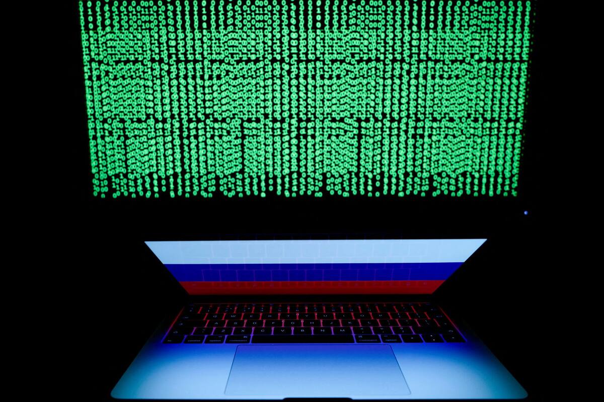 Un código digital en una pantalla ante un ordenador portátil con una bandera de Rusia.