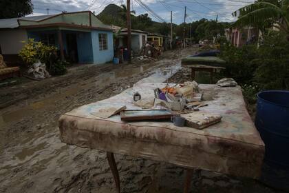 Un colchón y pertenencias personales se encuentran en una calle una semana después de que el huracán Oscar azotara la ciudad de Imías en la provincia de Guantánamo, Cuba, el martes 29 de octubre de 2024. (AP Foto/Ariel Ley, Pool)