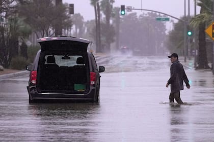 Un conductor acude a retirar pertenencias de su vehículo tras quedar varado en una calle inundada, el domingo 20 de agosto de 2023 en Palm Desert, California. Los meteorólogos advirtieron que la tormenta tropical Hilary era la primera tormenta tropical en golpear el sur de California en 84 años, y planteaba el riesgo a inundaciones, aludes de lodo, tornados aislados, vendavales y cortes de luz. (AP Foto/Mark J. Terrill)