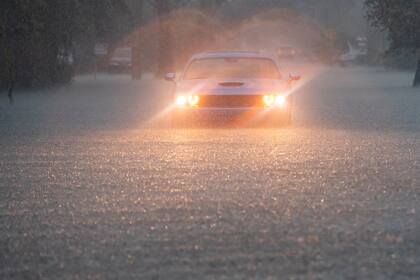 Un conductor parpadea sus luces de emergencia mientras cae una fuerte lluvia sobre partes del sur de Florida el miércoles 12 de junio de 2024, en Hollywood, Florida