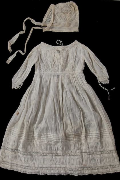 Un delicado conjunto de seda y gorro de Isabel cuando era bebé.