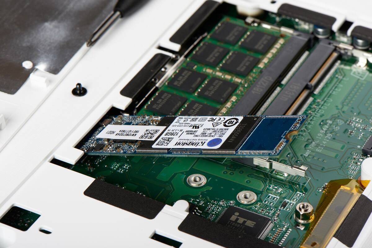 Un disco de estado sólido del tipo M.2, a medio camino de la instalación. Una vez insertado, baja hasta la rosca que se ve abajo y se lo ajusta con un tornillo. Son mucho más chicos que los SSD SATA convencionales