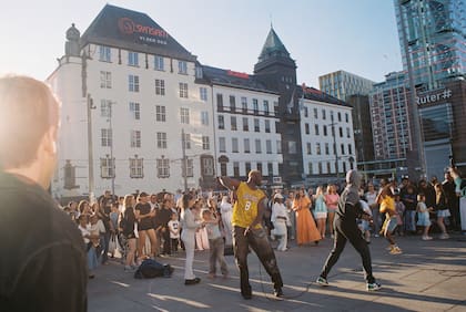 Un DJ actúa ante una multitud reunida en una plaza junto a la estación central de trenes de Oslo, Noruega, el 20 de junio de 2026