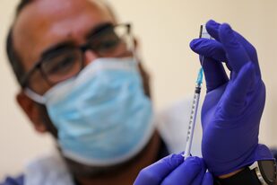 Un doctor se prepara para dar la vacuna de Pfizer/BioNtech contra el coronavirus en un centro de Londres