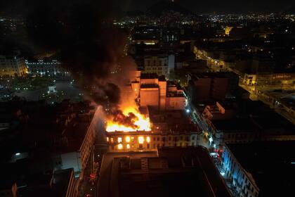Un edificio arde en medio de protestas antigubernamentales en el centro de Lima, Perú, el jueves 19 de enero de 2023. (AP Foto/Martín Mejía)