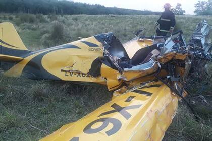 Un efectivo de Bomberos de la Policía de Misiones inspecciona la avioneta destrozada en el campo contiguo a la pista de Parada Leis.