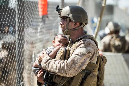 Un efectivo del Cuerpo de Infantería de Marina de EEUU carga a un bebé durante las operaciones de evacuación en el Aeropuerto Internacional Hamid Karzai en Kabul