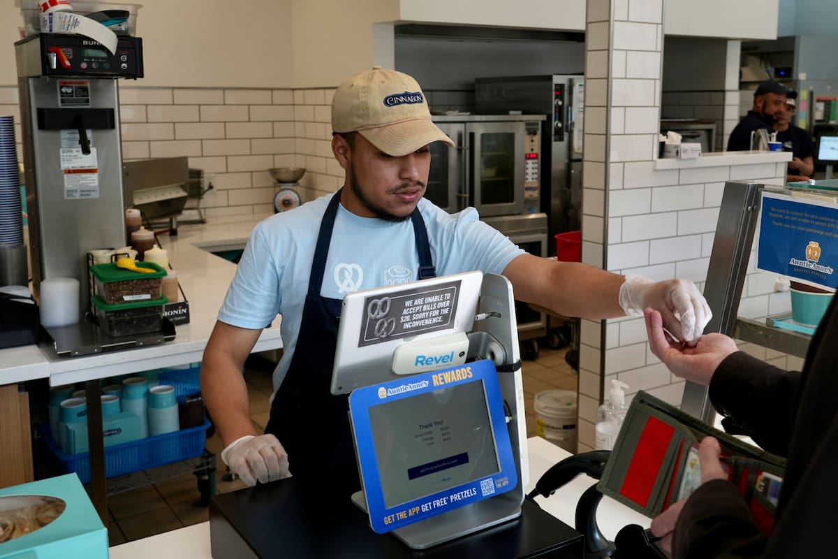 Un empleado cobra en un establecimiento Auntie Anne's and Cinnabon (AP Foto/Terry Chea)