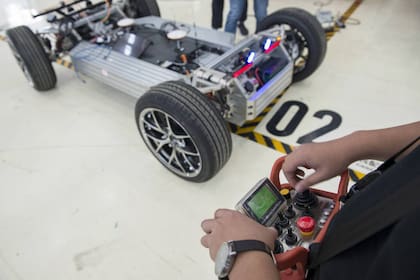 Un empleado de Pix Moving calibra con un control remoto los sistemas de conducción autónoma de uno de los chasis. Se hacen muchos kilómetros de prueba para afinar el algoritmo