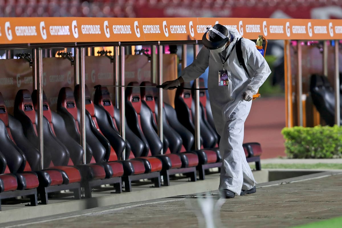Un empleado desinfecta los bancos de suplente en el estadio Morumbí