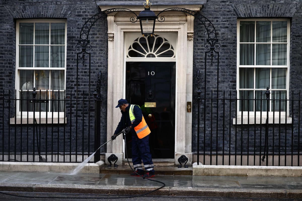 Un empleado limpia la entrada de Downing Street, la residencia del primer ministro